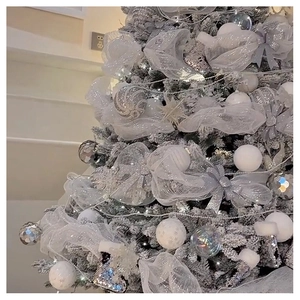 Detail of white and silver Christmas tree mesh ribbon and sparkling ornaments