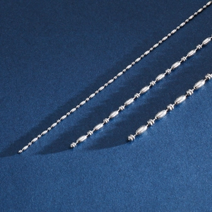 Détail macro de chaînes à perles de bambou en acier argenté sur fond sombre