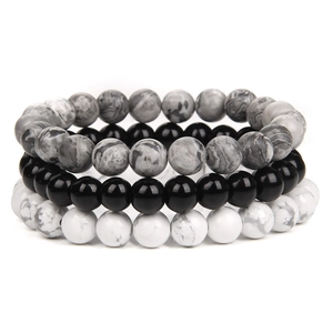 Close-up of a three-piece elastic bracelet set with black, white marble, and grey stone beads