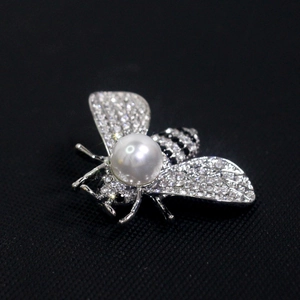 Detail of silver bee brooch with white pearls, sparkling zircons and black stripes