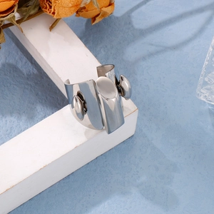 Close-up of polished silver stainless steel ring on white minimalist display stands