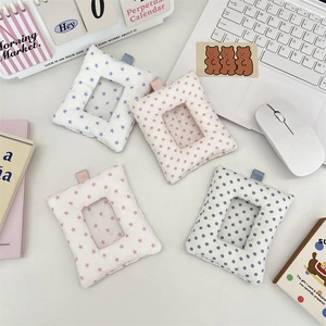 Detail of plush card holders with star patterns and clear window on a desk