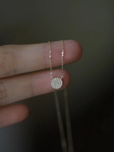 Detail of S925 silver 14k gold necklace with small micro-pave zircon round pendant