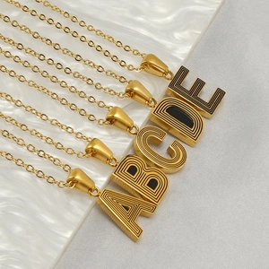 Detail view of gold letter pendants A-E with elegant black and gold striped metal design