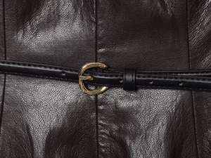 Vue détaillée du cuir marron foncé avec une ceinture noire et une boucle dorée