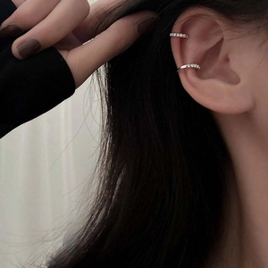 Close-up of minimalist silver metal ear cuffs on model showing a stylish non-pierced fit