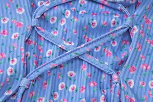 Nahaufnahme von hellblauem floralem Rippstoff mit rosa Print und Schnürungsdetails