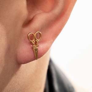 Boucle d'oreille ciseau dorée tendance en acier inoxydable portée par un mannequin