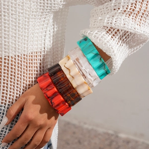 Detail of five assorted colorful acrylic resin bangle bracelets with marbled texture on wrist