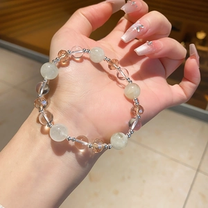 Detailed close-up of a multi-colored crystal bead bracelet on a woman's wrist
