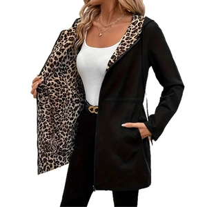 Detail einer langen schwarzen Damenjacke mit Leopardenmuster-Futter und Reißverschluss