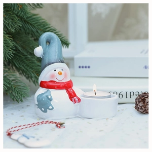 Cozy Christmas snowman candle holder with white body, red scarf, and a lit tea light