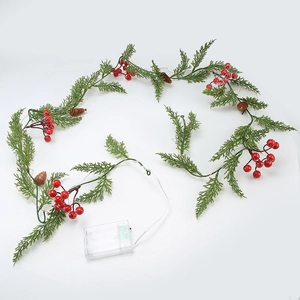 Artificial Christmas garland with green pine needles, red berries and pine cones on white