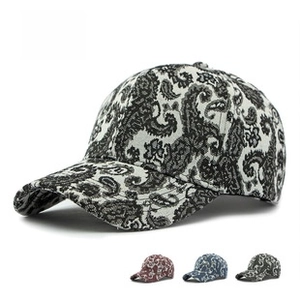 Detail of paisley print cotton baseball cap showing black, navy, red, and green colors