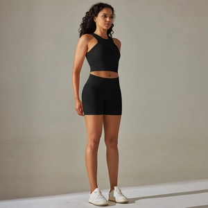 Detail of black seamless ribbed knit yoga set with halter sports bra and high-waist shorts