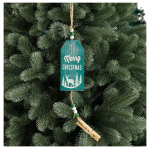 Detail of teal Christmas wooden tag with deer pattern hanging on tree branch