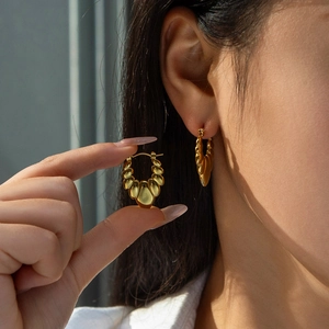 French vintage titanium steel irregular shell gold earrings worn by a model
