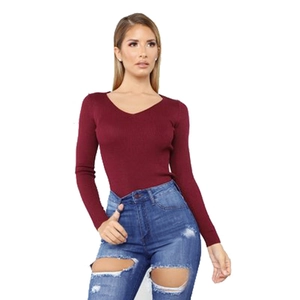Women's slim fit V-neck burgundy knit sweater paired with stylish ripped blue jeans