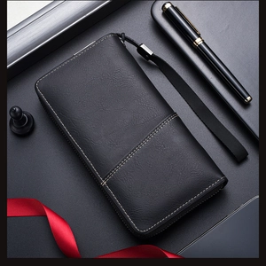 Detail of long black leather wallet with wristlet, pen and chess piece decoration