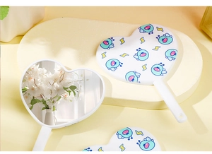 Detailed view of three heart-shaped handheld mirrors with floral reflection and bee patterns