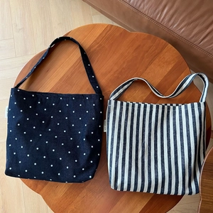 Detail of polka dot and striped canvas tote bags featuring simple wish side labels