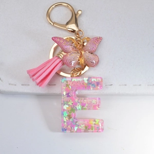 Pink glitter letter E keychain with resin butterfly charms and a leather tassel
