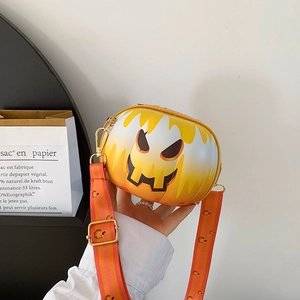 Detail view of the smiling Jack-o'-lantern pumpkin crossbody bag with striped strap
