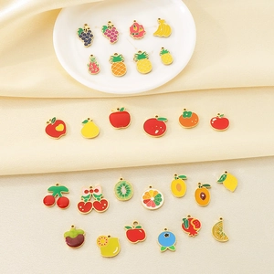 Assorted colorful enamel fruit charms in 18K gold plated stainless steel on white plate