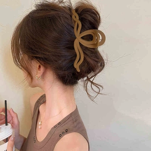 Dettaglio di un fermaglio per capelli a fiori marrone opaco indossato con stile naturale