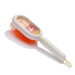 Detail of child hairbrush with transparent back featuring cartoon bear and duck motifs