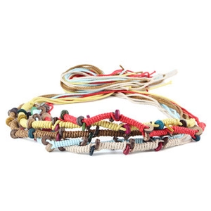 Detail of colorful hand-woven ethnic rope with wooden beads and braided textures