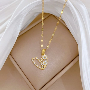Macro detail of gold hollow heart necklace with sparkling zircon and flower accent