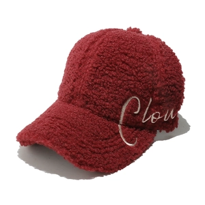 Detail of burgundy fleece baseball cap with white Cloud embroidery and plush texture