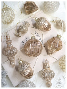 Detailed close-up of champagne gold glitter Christmas ornaments with unique textures