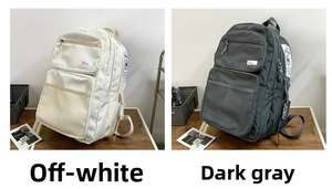Detail view of large-capacity backpacks in off-white and dark gray with zipper pockets