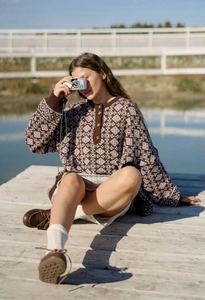 Vue détaillée du pull en maille marron vintage avec motif géométrique et bouton au col