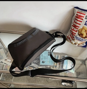 Vue détaillée de l'imprimé du logo WEPOWER FASHION sur un sac bandoulière en cuir techwear