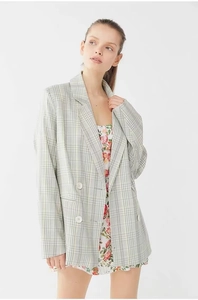 Detailed close-up of gray plaid double-breasted blazer with classic notched lapels