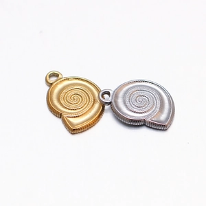 Detailed view of conch shell pendants in gold and silver finish with spiral texture