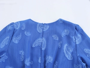 Détail de la robe bleue avec jacquard paisley, manches bouffantes et zip dos
