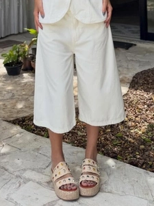 White wide-leg cropped pants paired with colorful studded platform sandals for summer