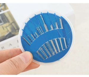 Detail of round blue sewing needle kit showing various sizes of steel needles