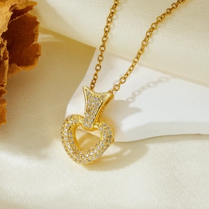 Macro shot of gold heart pendant with white cubic zirconia pavé on an elegant necklace