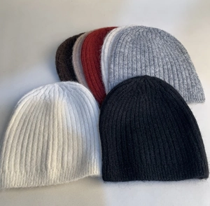 Detailed knit texture of wool blend beanies in various colors like grey and burgundy
