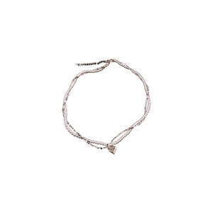 Double-layer necklace featuring white pearls and a silver heart pendant on white background
