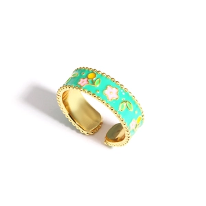 Detail of flower enamel adjustable ring with mint green base and pink floral patterns