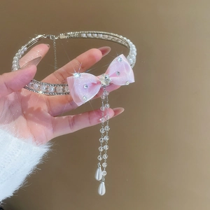 Detail of pearl choker with pink bow and sparkling rhinestone fringe for women