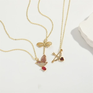 Golden necklace set with hummingbird, dragonfly, and heart arrow pendants and red zircon