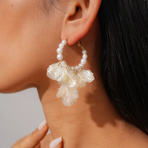 Close-up of pearl petal earrings worn by a model showcasing the elegant golden hoop design