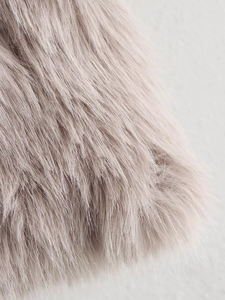 Primo piano della trama in ecopelliccia grigio chiaro a fibre lunghe di un cappotto